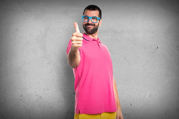 Homem em roupas coloridas com polegar para cima — Fotografia de Stock
