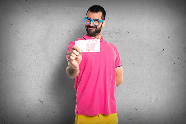 Homme avec des vêtements colorés prenant beaucoup d'argent — Photo