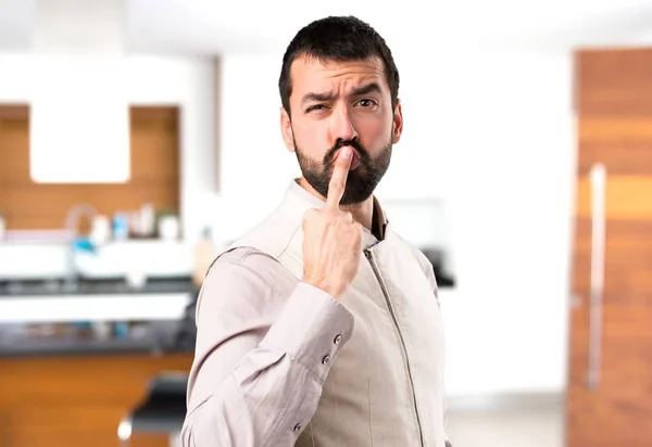 Bonito homem com colete fazendo gesto chifre dentro da casa — Fotografia de Stock