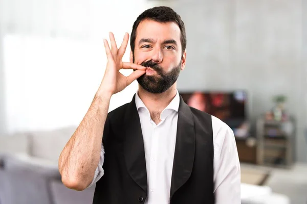 Cool man making silence gesture inside house