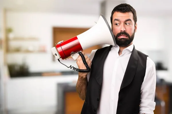 Cool man holding a megaphone inside house