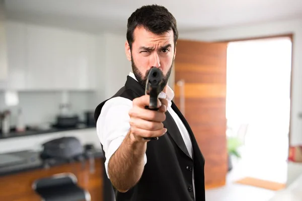 Homem legal segurando uma pistola dentro da casa — Fotografia de Stock