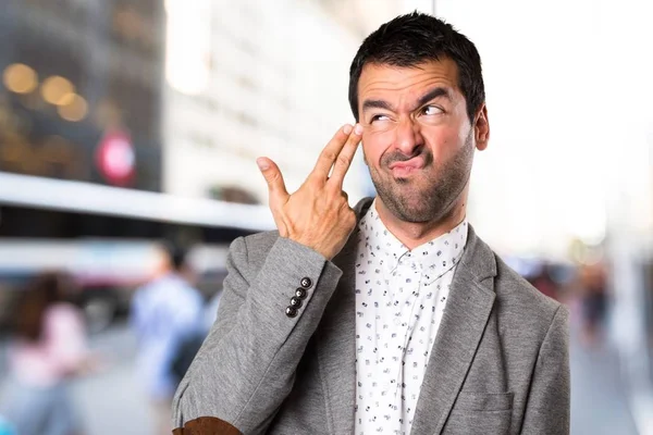 Yakışıklı adam yapma intihar jest odaklanmamış arka plan üzerinde