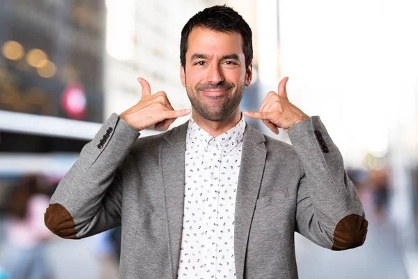 Yakışıklı adam yapım telefon jest odaklanmamış arka plan üzerinde