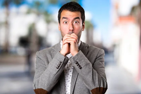 Handsome man pleading on unfocused background — Stock Photo, Image