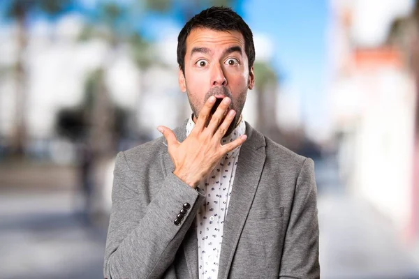 Yakışıklı adam yapma sürpriz jest odaklanmamış arka plan üzerinde