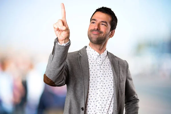 Handsome man touching on transparent screen on unfocused background — Stock Photo, Image