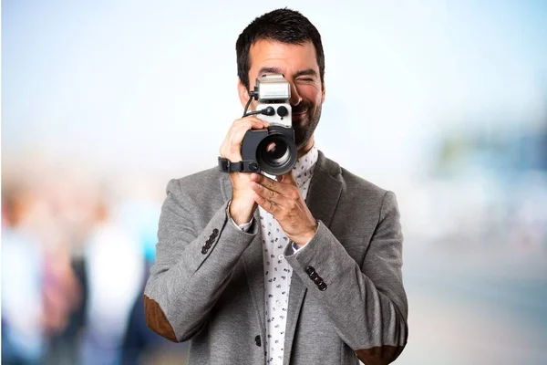 Bonito homem filmando em fundo desfocado — Fotografia de Stock