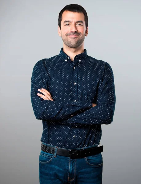 Hombre guapo con los brazos cruzados sobre fondo gris — Foto de Stock