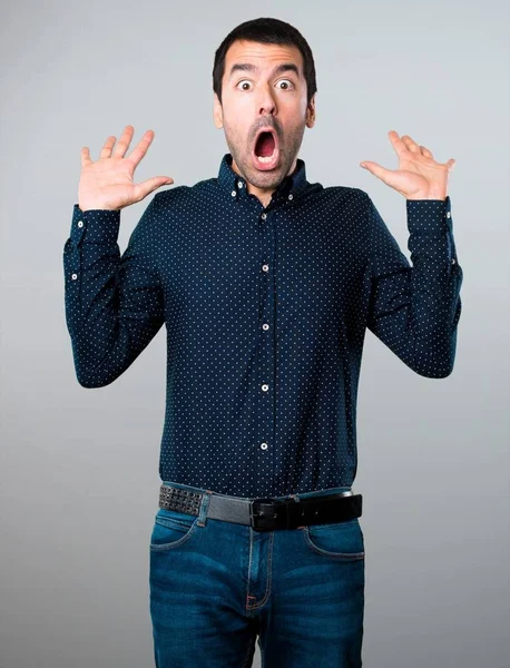 Yakışıklı adam yapma sürpriz jest gri arka plan üzerinde