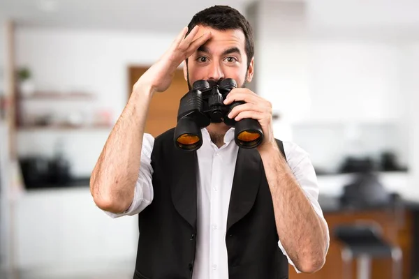 Cool man with binoculars inside house — Stock Photo, Image
