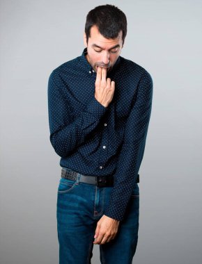 Yakışıklı adam gri arka plan üzerine kusma jest yapma