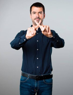 Yakışıklı adam gri arka plan üzerinde hiçbir hareketi yapma