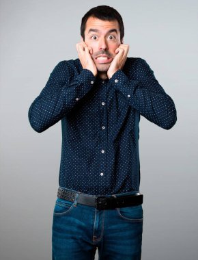 Gri arka plan üzerinde korkmuş yakışıklı adam