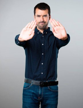 Yakışıklı adam gri arka plan üzerinde kırmızı yapma