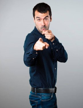 Yakışıklı adam gri arka plan üzerine açık için işaret