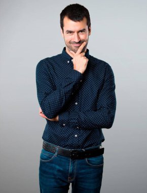 Yakışıklı adam gri arka plan üzerinde düşünme