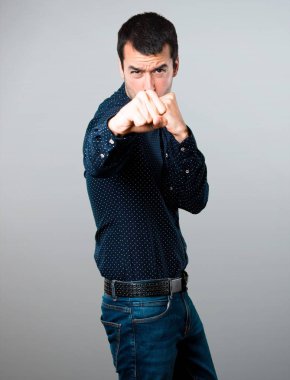 Yakışıklı adam gri arka plan üzerinde mücadele