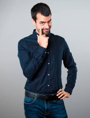 Yakışıklı adam bir şey gri arka plan üzerinde gösterilen