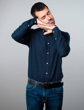 Yakışıklı adam yapma uyku jest gri arka plan üzerinde