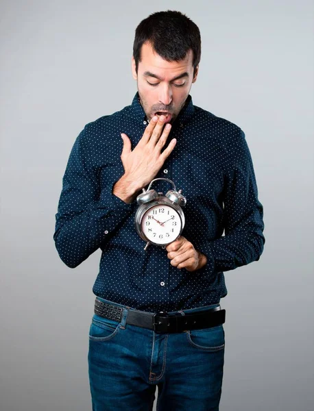 Bel homme tenant horloge vintage sur fond gris — Photo