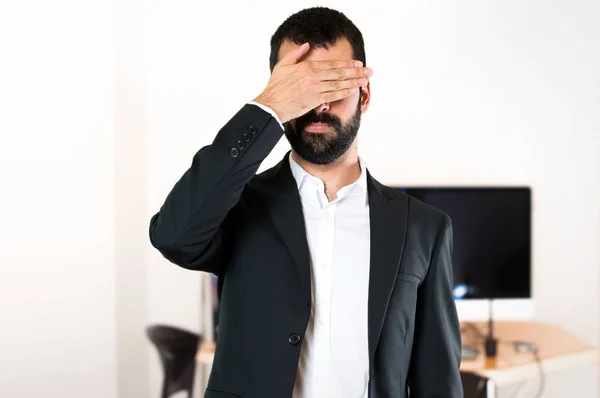 Schöner Geschäftsmann, der sein Gesicht im Büro verhüllt — Stockfoto