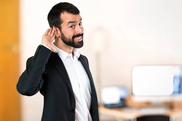 Handsome businessman listening something in the office — Stock Photo, Image