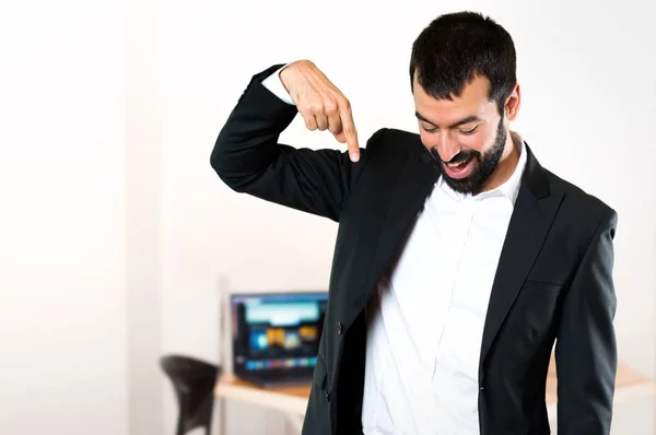 Schöner Geschäftsmann, der im Büro nach unten zeigt — Stockfoto