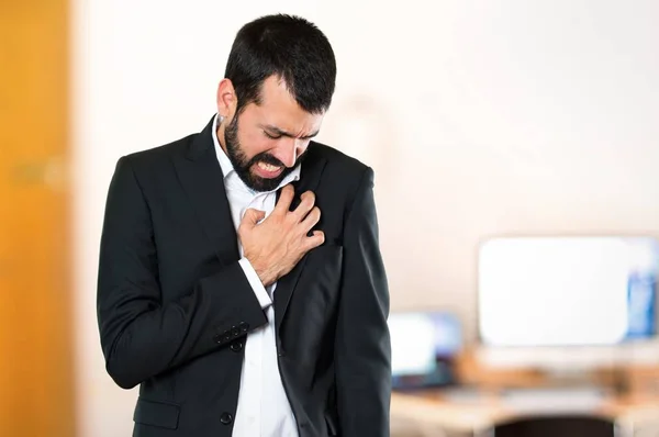 Schöner Geschäftsmann mit Herzschmerzen im Büro — Stockfoto