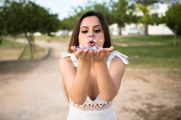 Schönes junges Mädchen in einem Park mit Konfetti — Stockfoto