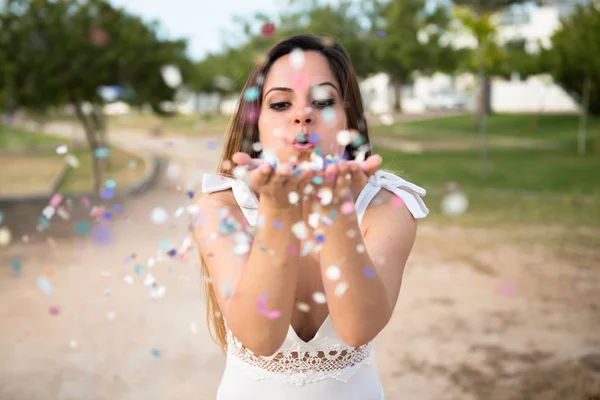 Schönes junges Mädchen in einem Park mit Konfetti — Stockfoto
