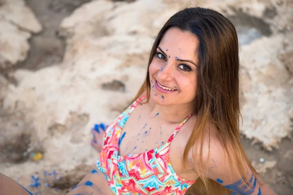 Vacker ung flicka i stranden med blå färg holi — Stockfoto