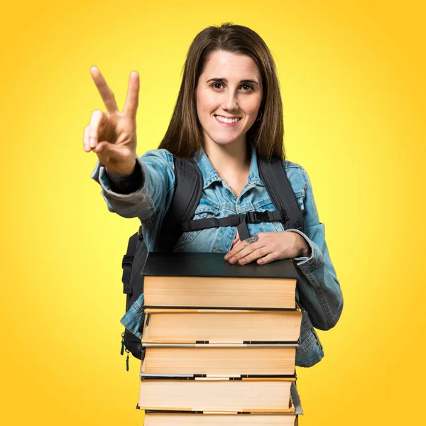 Adolescente estudiante chica con un montón de libros y contando dos — Foto de Stock