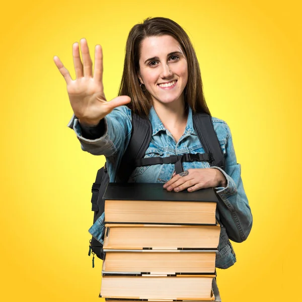 Adolescente estudiante chica con un montón de libros y contar cinco — Foto de Stock