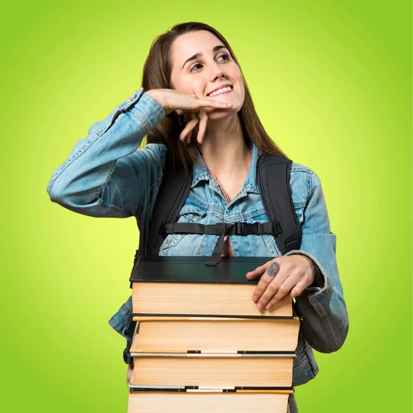 Девочка-подросток с большим количеством книг и жестом телефона — стоковое фото