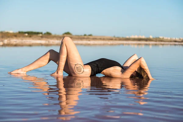 Ung flicka i svart baddräkt på stranden — Stockfoto