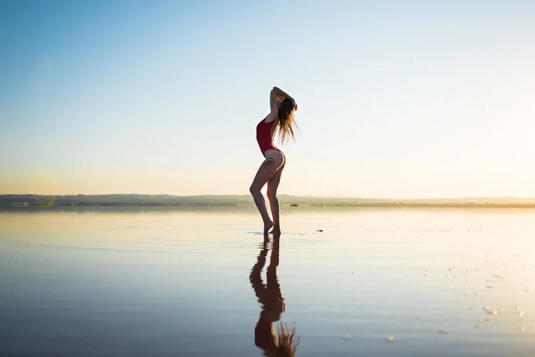 समुद्र तट वर लाल स्विमिंग सूट मध्ये युवा मुलगी — स्टॉक फोटो, इमेज