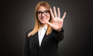 Genç iş kadını beş koyu arka plan üzerinde sayma