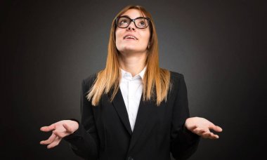 Genç iş kadını koyu arka plan üzerinde zen pozisyonda