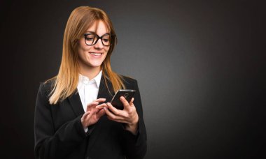 Genç iş kadın koyu arka plan üzerinde için mobil söz