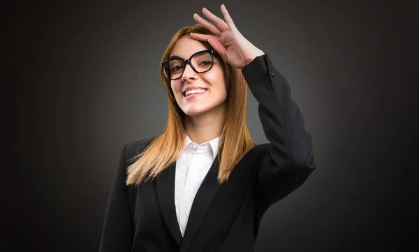 Young business woman saluting on dark background — Stock Photo, Image