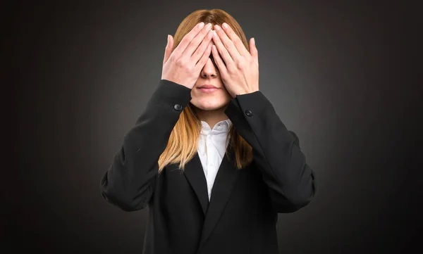 Young business woman covering her eyes on dark background — Stock Photo, Image