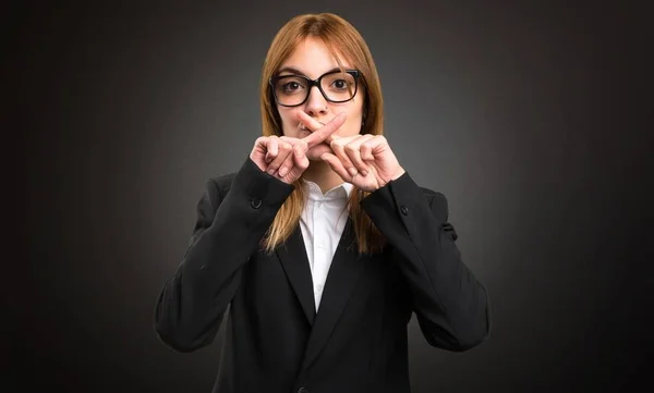 Jonge zakelijke vrouw maken stilte gebaar op donkere achtergrond — Stockfoto