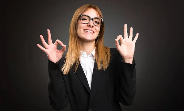 Ung affärskvinna gör Ok logga på mörk bakgrund — Stockfoto