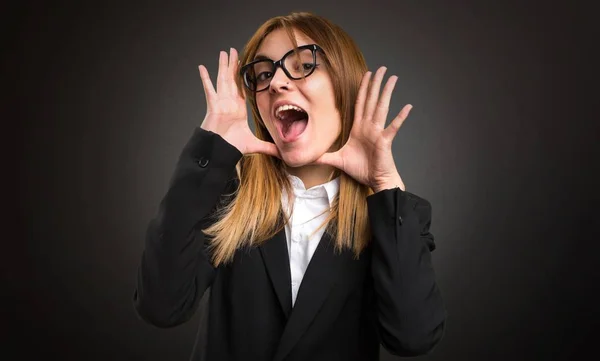 Joven mujer de negocios haciendo gesto sorpresa sobre fondo oscuro —  Fotos de Stock