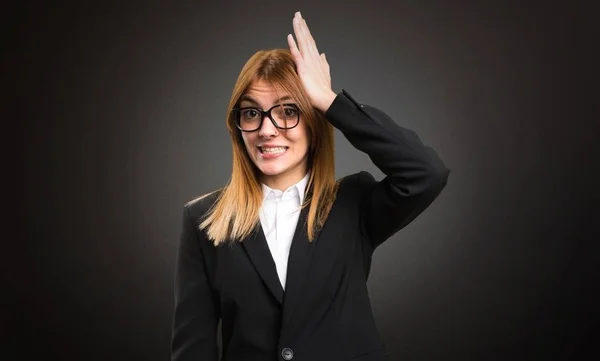 Junge Geschäftsfrau zweifelt an dunklem Hintergrund — Stockfoto