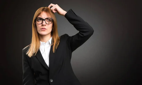 Joven mujer de negocios que tiene dudas sobre fondo oscuro —  Fotos de Stock