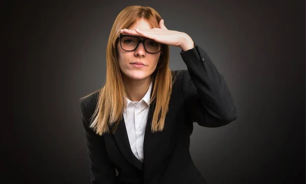 Young business woman showing something on dark background — Stock Photo, Image