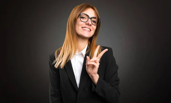 Молодая деловая женщина делает победный жест на темном фоне — стоковое фото
