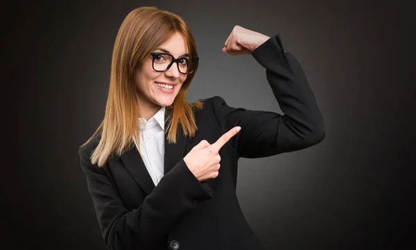 Young business woman making strong gesture on dark background — Stock Photo, Image